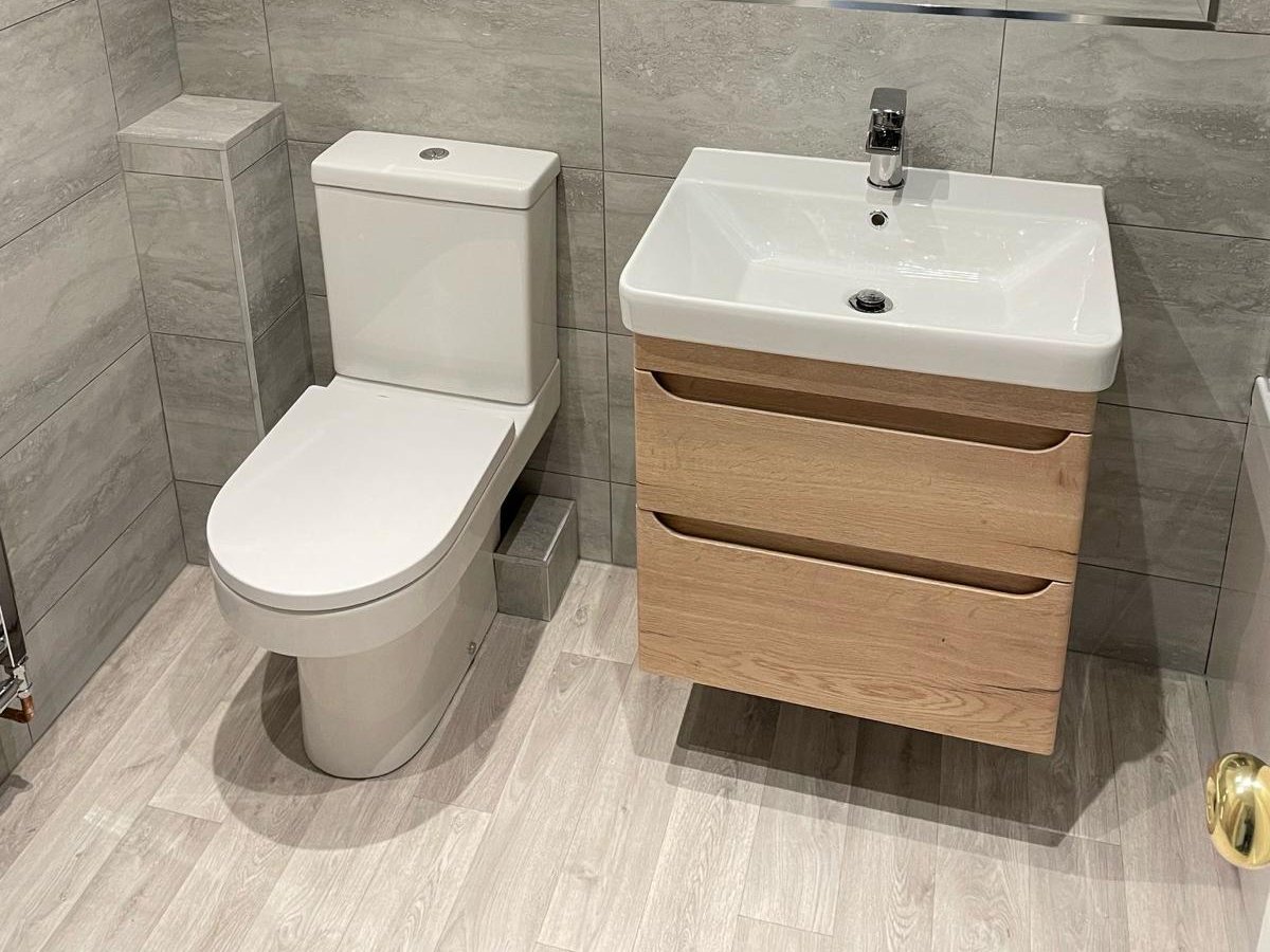 Bathroom with a close coupled toilet and an oak vanity unit with a white basin