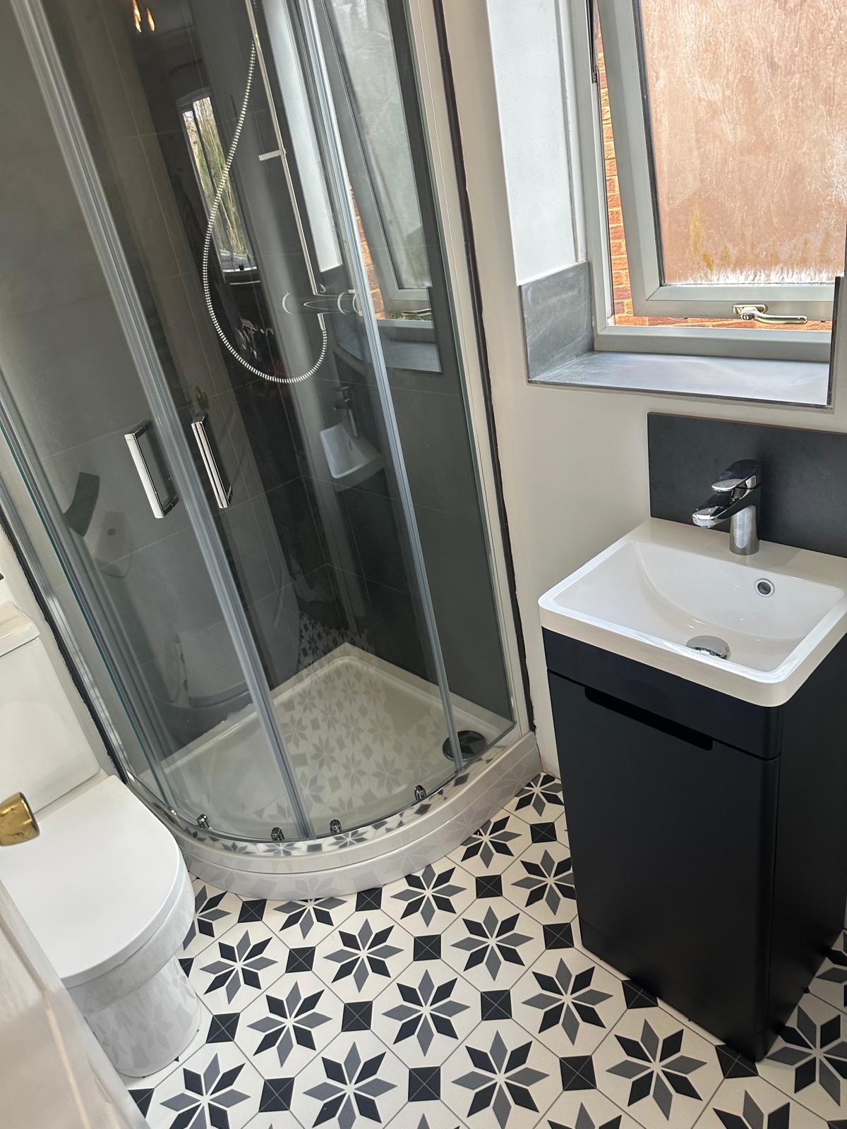 Small shower room with a quadrant enclosure and patterned floor tiling