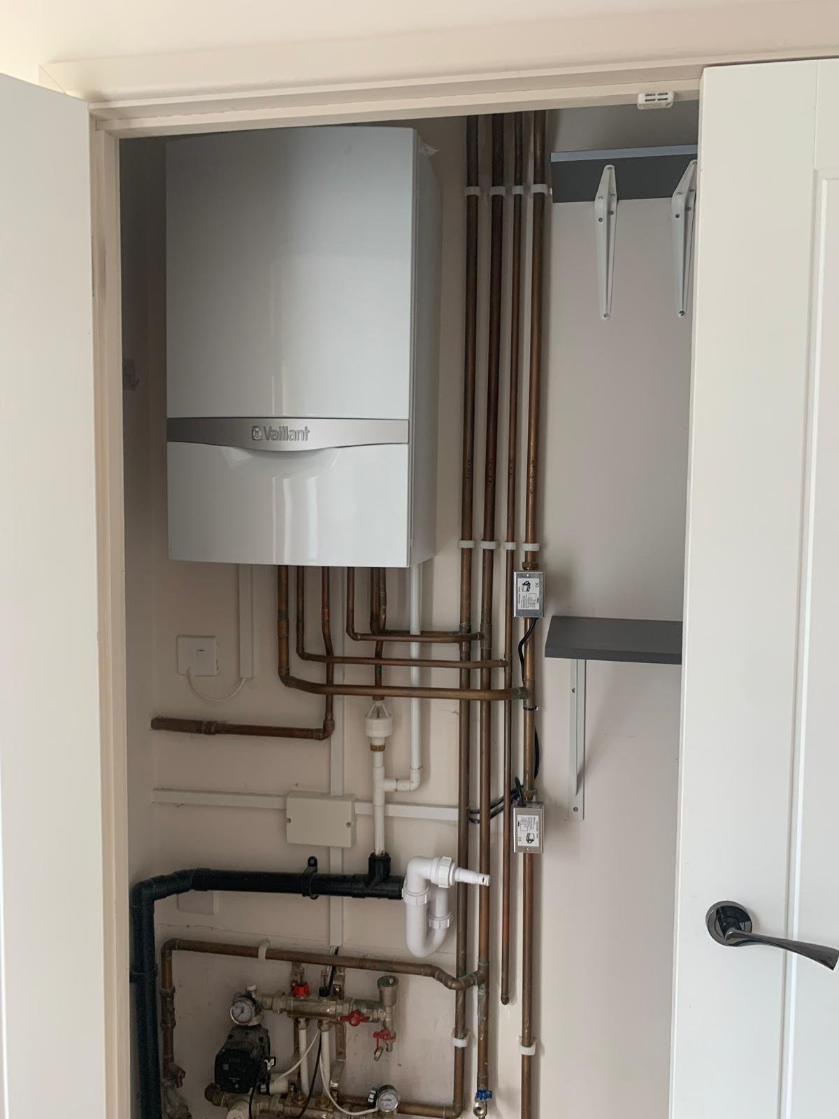 Vaillant boiler and copper manifold installed in an airing cupboard