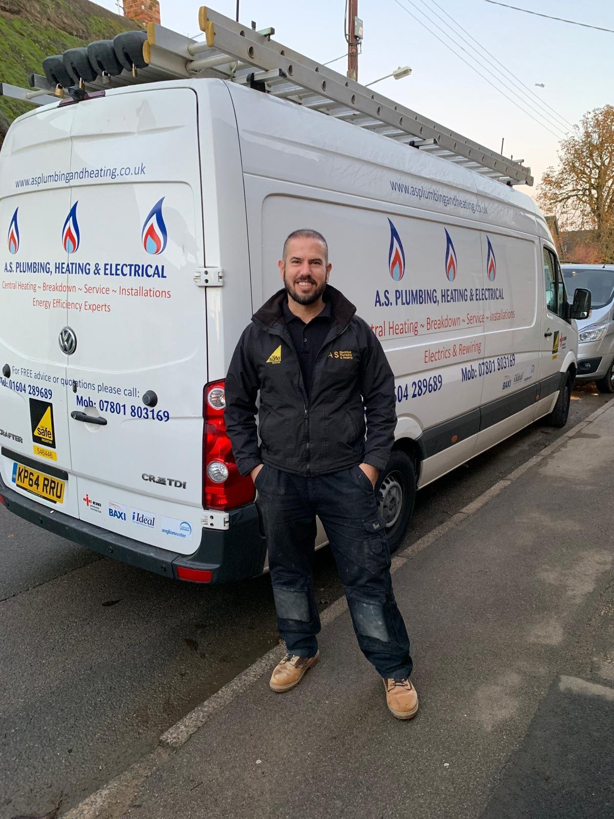 The owner of A S Plumbing and Heating standing beside the company branded van